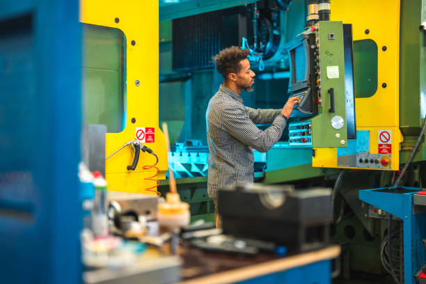 istock Black Mid Adult Male Worker Programming CNC Machine 1499869395