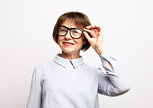 Old woman wear eyeglasses over white background.