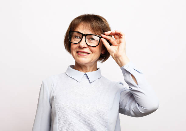 Old woman wear eyeglasses over white background. stock photo