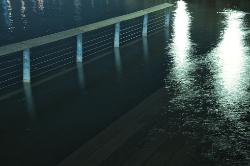 image of handrail on the water and reflection of lights