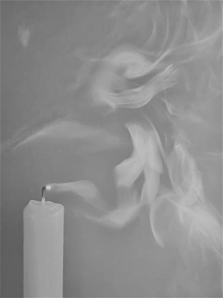 istock White candles on a gray background with smoke 1499888882