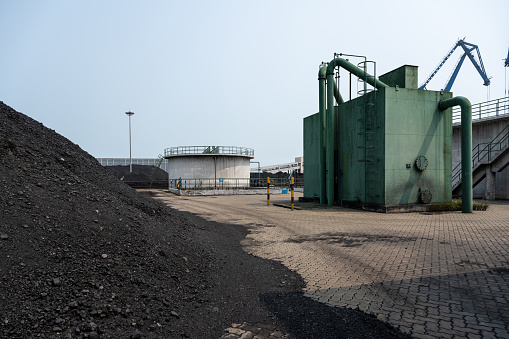 Panoramic gravel pit in mountain area with machinery and distribution tapes gravel according sizes, lots of gravel and sand for construction industry. We also see debris storage terraces or waste coal power plant in the background - Panoramic view of gravel in mountain area with machinery and gravel distribution tapes according to sizes, with piles of gravel and sand for the construction industry. We also see storage terraces for debris or waste from coal power plant in the background