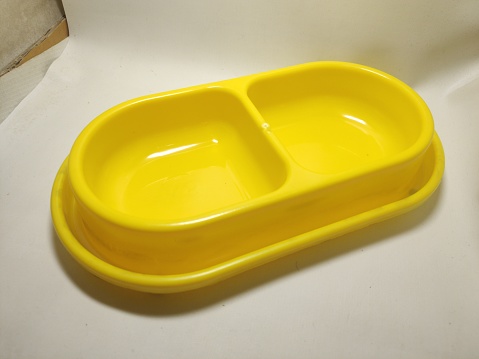 Cat or dog feeding place, yellow, anti-ants, or other animals that eat their food, there are two containers for storing food and water, or food and snacks, made from good materials. white background
