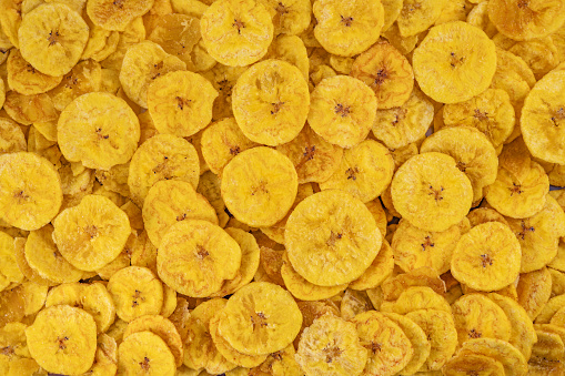 Pile of dehydrated fried banana chips with salt, top view. Chifles, tostones o patacones. Top view of typical traditional dish of Latin American gastronomy called Chifles or fried tostones. Platano.