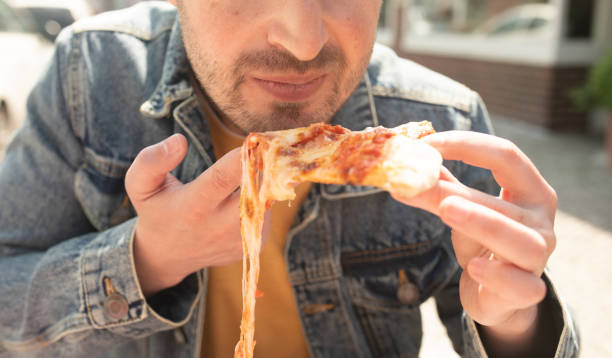 istock Man eating a slice of pizza in cafe. 1499911807