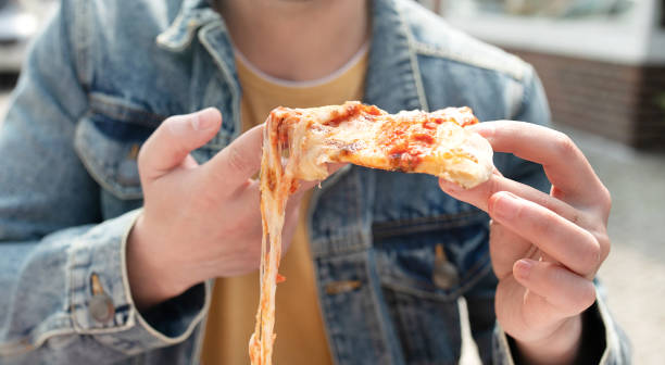 istock Hand grabbing slice of cheesy pizza. 1499912088
