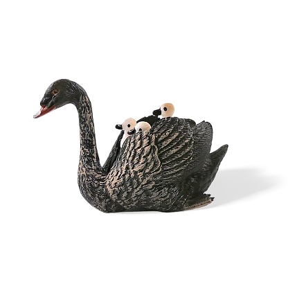 Closeup shot of miniature toy animals black swan and duckling riding on their mother on white background