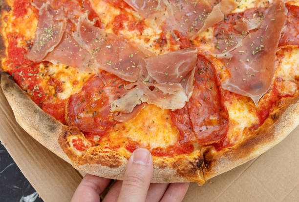 istock Person hand taking piece of pizza. 1499916203