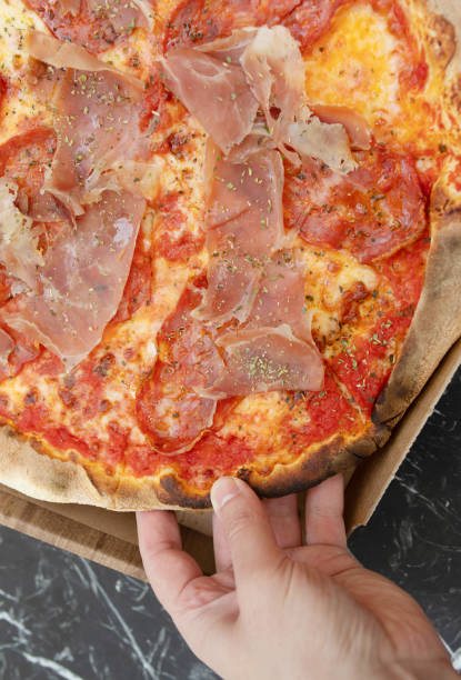 istock Person hand taking piece of pizza. 1499916209