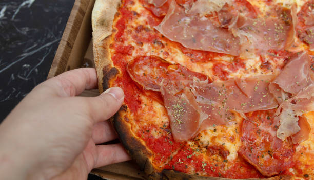 istock Person hand taking piece of pizza. 1499916212