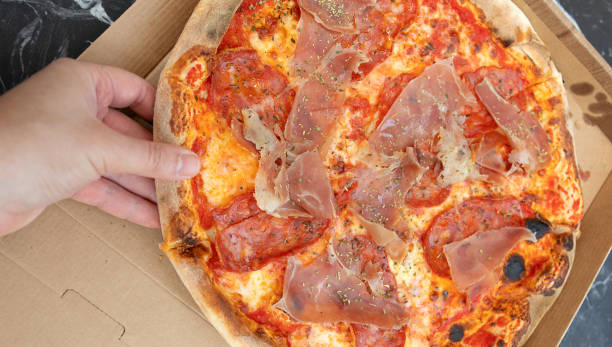 istock Person hand taking piece of pizza. 1499916214