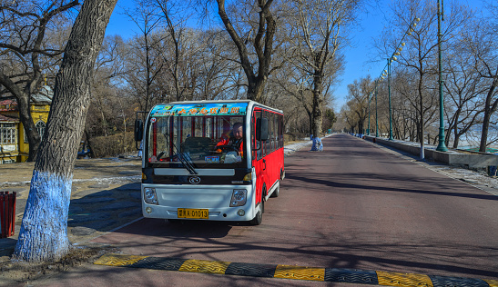 Harbin, China - Feb 27, 2018. Tourist bus waiting at tree park in Harbin, China. Harbin is largest city in the northeastern region of China.