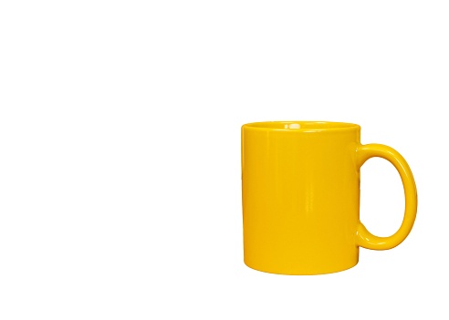 Yellow tea cup isolated on a white background with copy space.