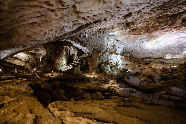 istock underground, large white cave with lit lights and walkway leading to a cave with rocks 1499920970