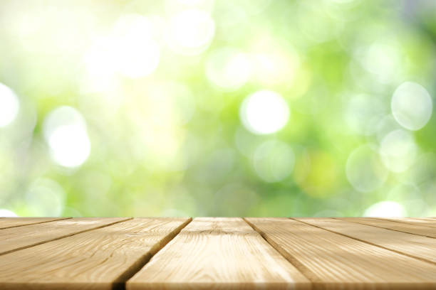 istock Empty wooden table with Blurred image of abstract circular green bokeh from nature style background. 1499921715