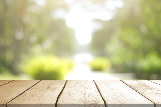 istock Empty wooden table with Blurred image of abstract circular green bokeh from nature style background. 1499921722