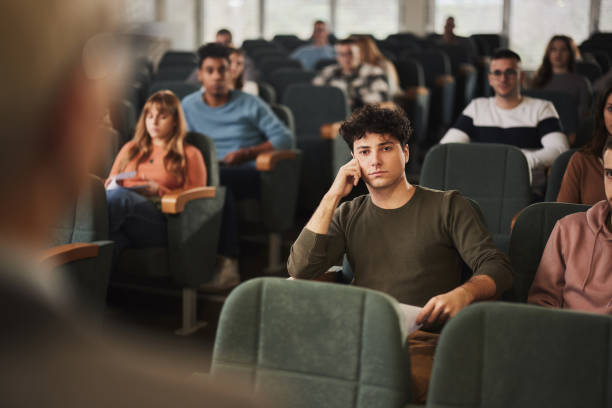 istock Male student attending a class in a lecture hall at university. 1499921974