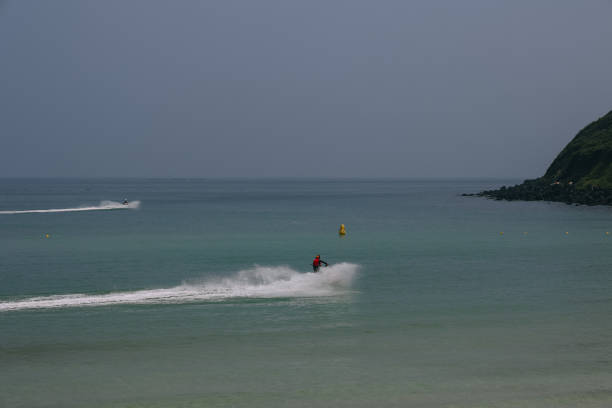 Tourist diving into the sea from a boat, creating a big splash