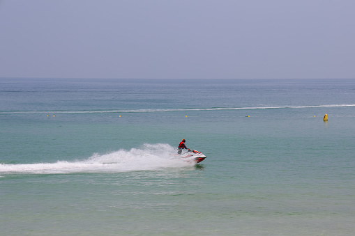 Jeju Island, South Korea - July 10, 2022: Man speeding on jet ski on the sea during summer in Jeju island, South Korea.