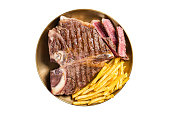 Roast Italian Florentine or porterhouse beef meat Steak in a plate with french fries.  Isolated on white background.