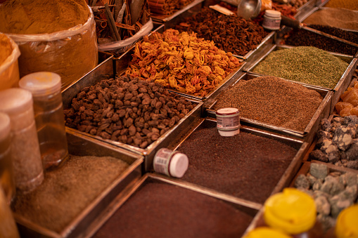 Various powdered spices, nuts and seeds in assortment sold at Goa market. Seasonings in huge, square containers selling. Whole and mixed spices, sweet, hot seasonings on commerce in India.