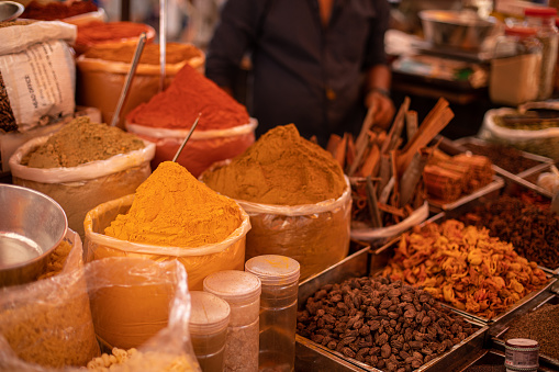 Assorted colorful, mixed spices selling at Goa trading. Salesman sell different grounded flavorings on commerce. Aromatic, whole and mixed seasonings, nuts and seeds in traditional Indian market.