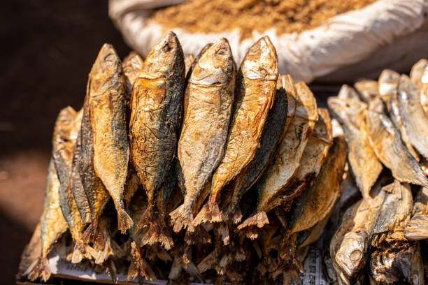 kleiner haufen getrockneter kleiner fische, die auf dem markt in indien in folie ausgelegt sind. gekochte meeresfrüchte, die auf dem basar im wunderschönen goa verkauft werden. - getrockneter fisch stock-fotos und bilder