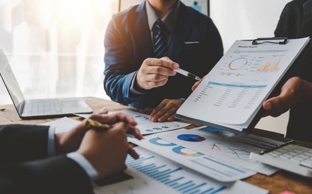 istock Young colleagues discuss business and analytical price charts using calculators and laptops to calculate financial, tax, accounting, statistics and analytical research ideas. 1499929319