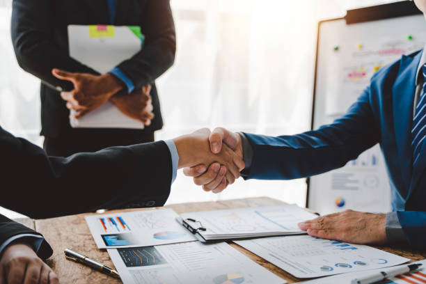business partner handshake concept colleagues shaking hands successful deal after a great meeting. blurred background. - onesie imagens e fotografias de stock