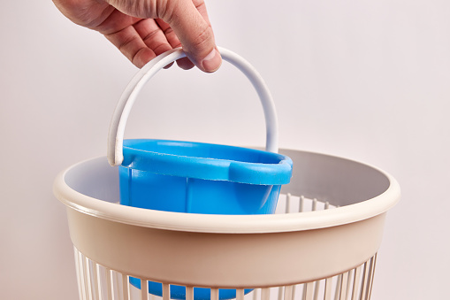 A plastic children's bucket is thrown into the trash.
Disposal and recycling of waste.