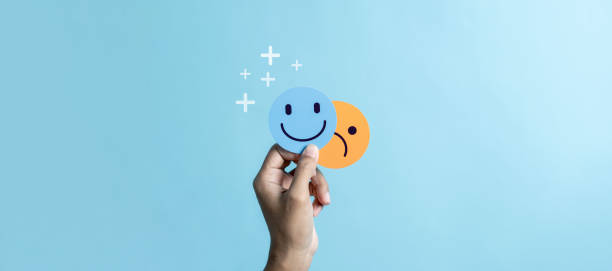istock Hands holding sad face hiding or behind happy smiley face, bipolar and depression, mental health concept, personality, mood change, therapy healing split concept. 1499937403