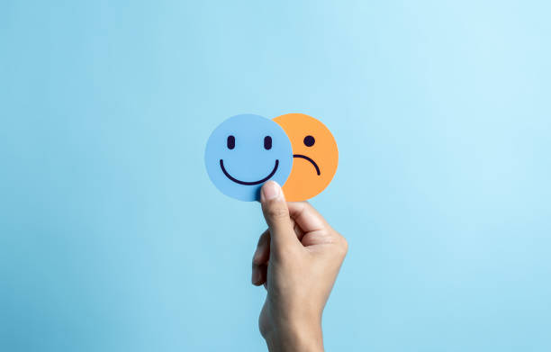 istock Hands holding sad face hiding or behind happy smiley face, bipolar and depression, mental health concept, personality, mood change, therapy healing split concept. 1499937405