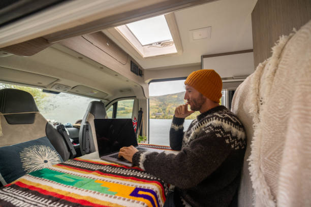 istock Man working remotely, van life concept 1499938925