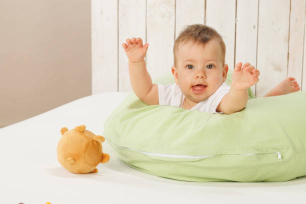 Happy baby,  play with toy, lying down on front.