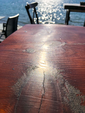 Top down Flat Lay red wooden coffee table next to the sea with chairs