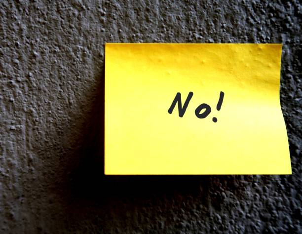 istock A yellow note pad on the grey rough textured cement wall, with a message NO! , concept of rejection 1499943245