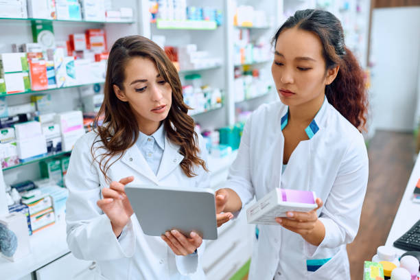 istock Female pharmacists cooperating while using touchpad and working in drugstore. 1499945843