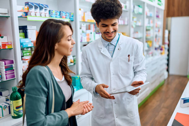 istock Happy pharmacist and his female customer using touchpad in a pharmacy. 1499946013