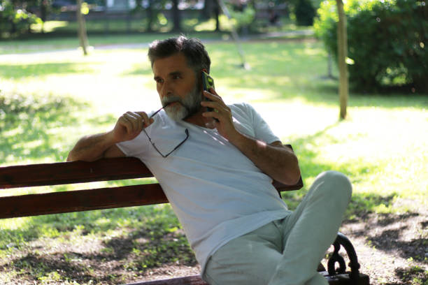istock Senior casual man using phone in public park 1499946510
