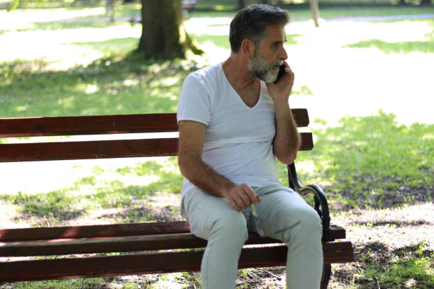 istock Senior casual man using phone in public park 1499946559