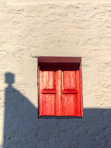 White wall and red window and shadow