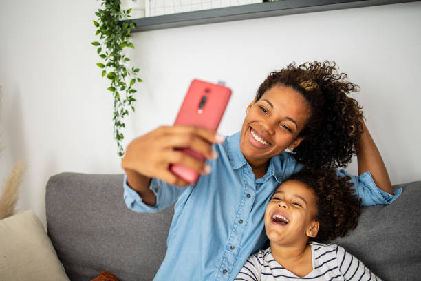 istock Mother and daughter using mobile phone to make selfie 1499947935
