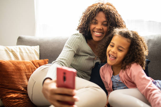 istock Mother and daughter at home taking selfie 1499948046