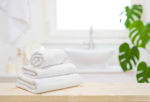 istock White folded towels on wooden table top in blurred bathroom 1499948154