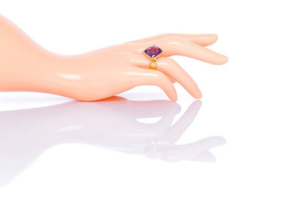 アメジストジュエルまたは宝石は、プラスチック製のマネキンの女性の手にリングを付けます。天然宝石アクセサリーのコレクション。スタジオショット