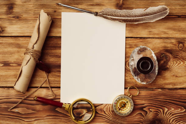 istock Old paper on brown wood background with feather 1499952732