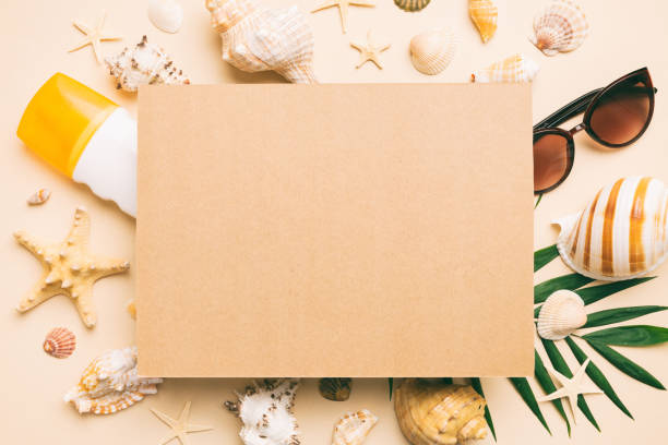 istock Summer time concept with blank greeting card and blank craft paper on colored background. Seashells from ocean shore in the shape of frame separated with space for text top view 1499953687