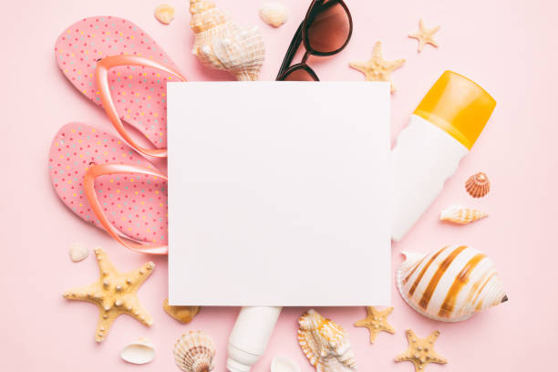 istock Summer time concept with blank greeting card and blank white paper on colored background. Seashells from ocean shore in the shape of frame separated with space for text top view 1499953697