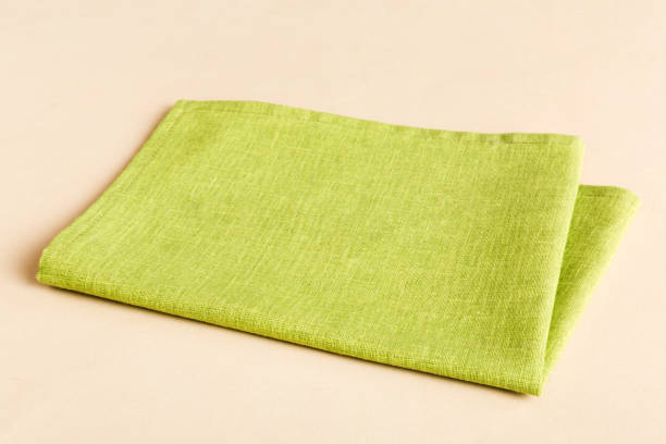 istock top view with green kitchen napkin isolated on table background. Folded cloth for mockup with copy space, Flat lay. Minimal style 1499953767