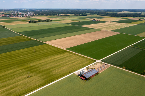 Green agricultural landscape in springtime with a barn viewed from above.